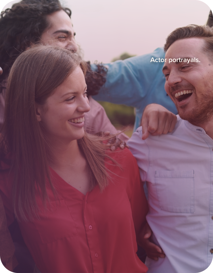 A group of people were standing and smiling in a park.